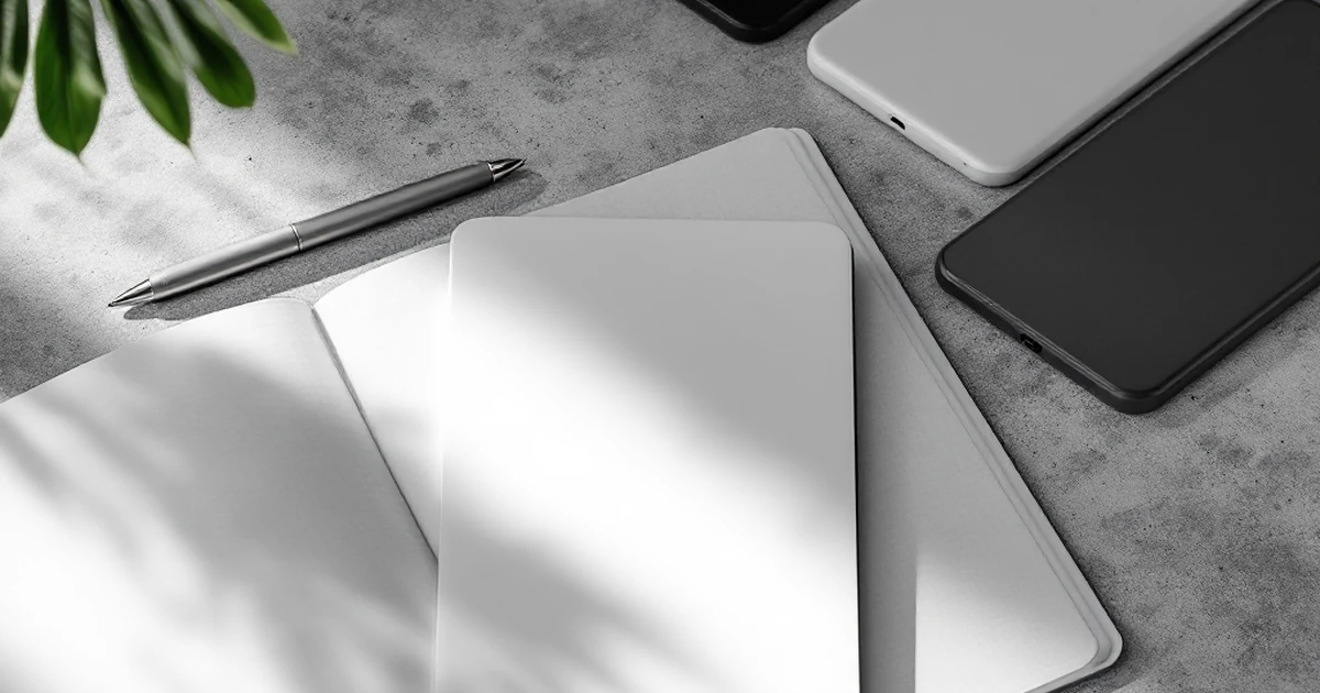 A notebook with a checklist, a pen, and device mockups on a concrete surface, representing mid-range options.